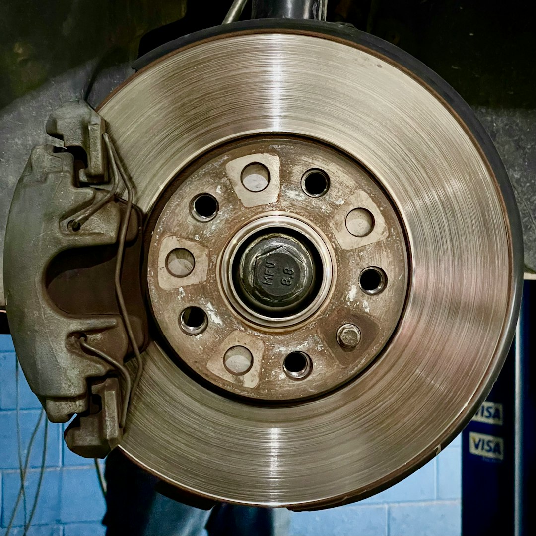 Close-up view of brake caliper and brake components at automotive repair shop