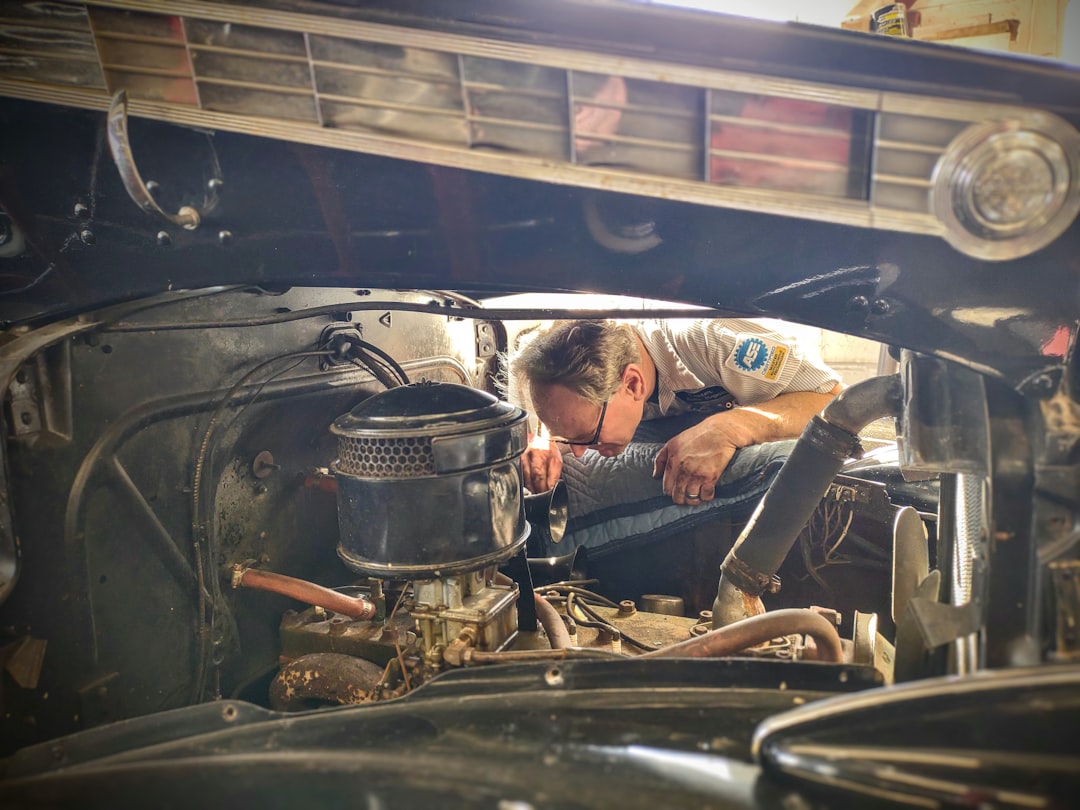 Expert mechanic performing engine diagnostic work in professional garage