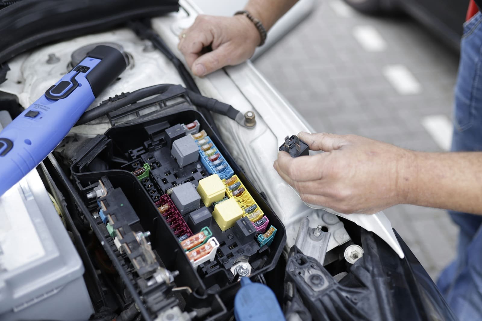 Mechanic testing a car battery and electrical system