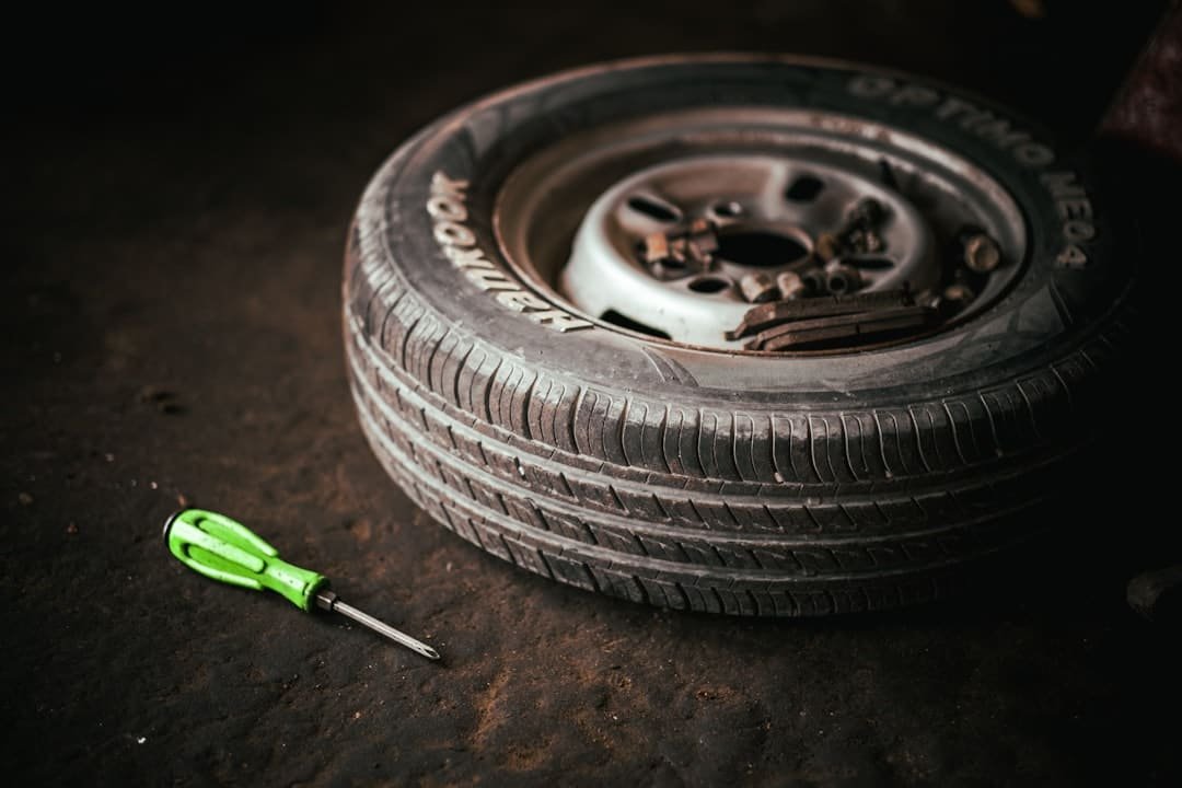 Removed wheel and tire beside a hand tool