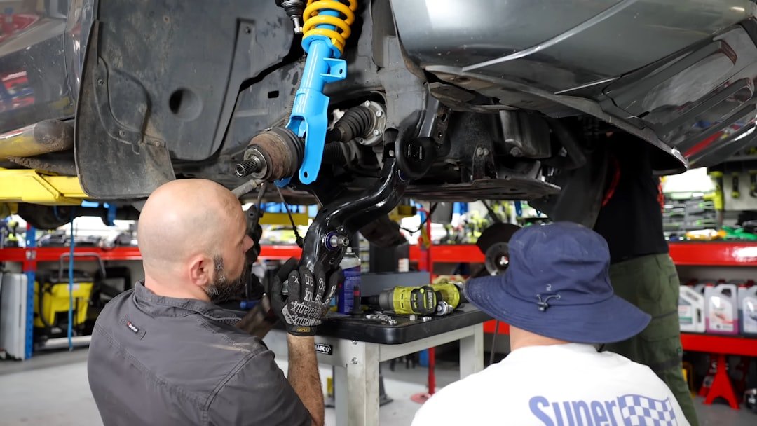 Professional transmission mechanics working in automotive repair shop